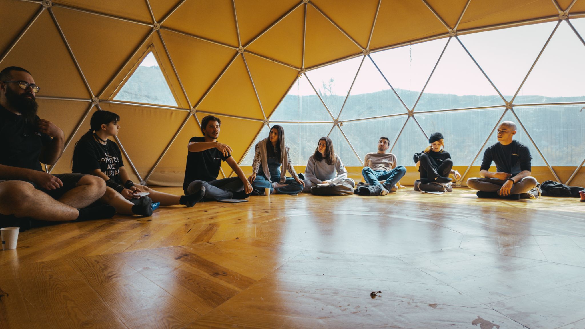 Team sitting in circle inside a geodesic dome during an offsite retreat